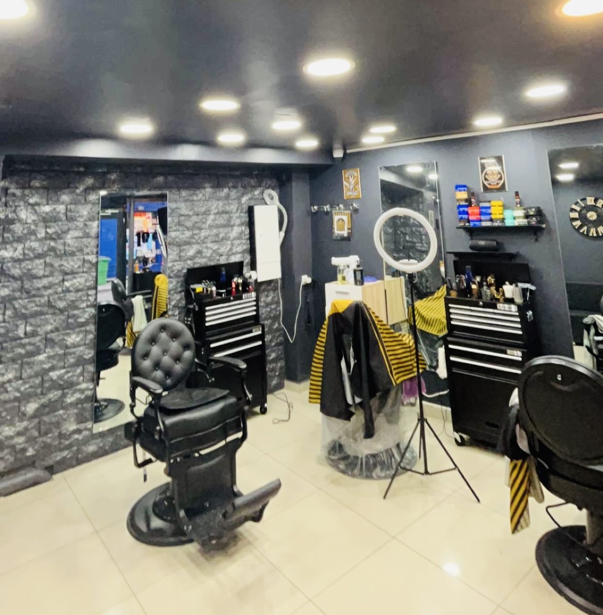L'intérieur du salon AZ Barber, fauteuils de barbier noirs et murs sombres